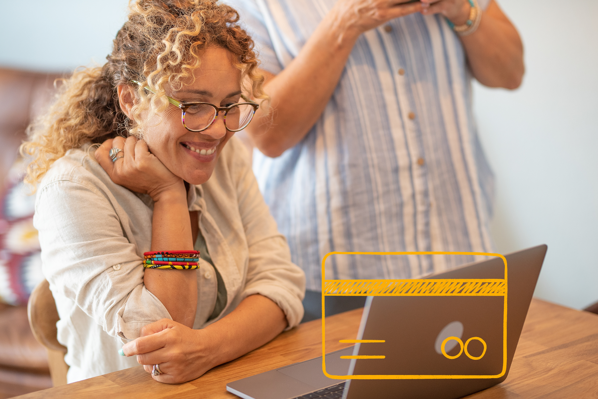 Kaks inimest kasutavad sülearvutit, krediitkaardi ikoon